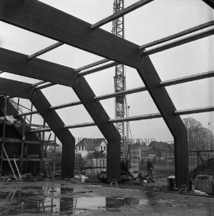 Tremsbüttel-Dorf: Gemeindezentrum: Mehrzweckhalle im Bau: Blick aus Gebäude auf Dachkonstruktion aus Holz-Leimbinder: draußen Kran und Bauarbeiter (Mitte): im Hintergrund Bauern- und Wohnhäuser