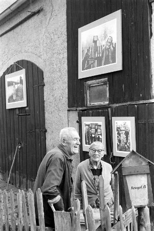 Das Ehepaar Kriegel vor Fotos der Freilichtausstellung in Erlln
