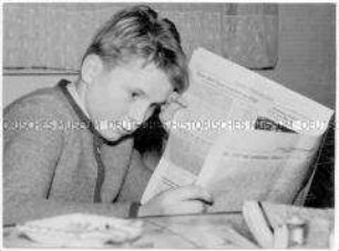 Junge liest Zeitung