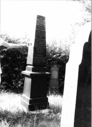 Grabstein 31 (Index: 100100538) Material: Granit Zustand: gut Maße HxBxT: 245x52x52 cm Beschreibung: Obelisk, mehrfach getreppter Sockel Besonderheit: Doppelgrab für Eheleute: Grabstein 31