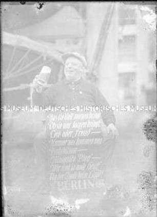 Mann mit Bierglas und einer Schrifttafel an Bord des Hochseepassagierdampfers "Berlin"