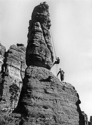 Sächsische Schweiz. Kletterfelsen (wohl im Bielatal), zwei Kletterer beim Abseilen
