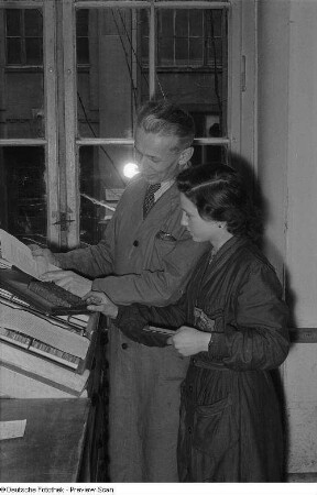 Meister mit Lehrling beim Schriftsetzen