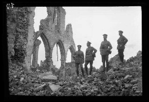 Nicht identifizierbare Ortschaft (Diksmuide (?) (Belgien): 4 Offiziere mit Schirmmützen auf einem Schutthaufen neben den spärlichen Mauerresten einer Kirche