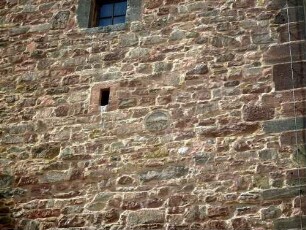 Kirchturm von Süden - Mittelgeschoss mit Werksteinen im Mauersteinverband sowie Kreissegmentscheibe (Bauornament) rechts unterhalb Schlitzfenster