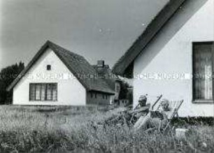 Urlauber vor reetgedecktem Fischerhaus auf der Ostseeinsel Hiddensee