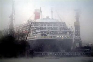 QUEEN MARY 2, größtes Kreuzfahrtschiff der Welt. Für Wartungsarbeiten gedockt bei der Werft Blohm + Voss im Hamburger Hafen, 11.2005 Auf der Elbe steht herbstlich/winterlicher Nebel