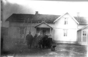 Photographien von Lappland. Gruppenaufnahme vor einem Holzhaus