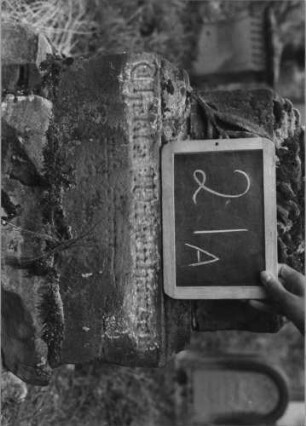 Grabstein 21 (Index: 100080694) Material: Säule Marmor, Sockel Sandstein Zustand: Sockel verwittert Maße HxBxT: 180x41x37 cm Beschreibung: getreppter Sockel, unterster Teil rustica, abgebrochene Säule Symbolik: Plamzweige auf Sockel, Tuch über Säule: Grabstein 21A