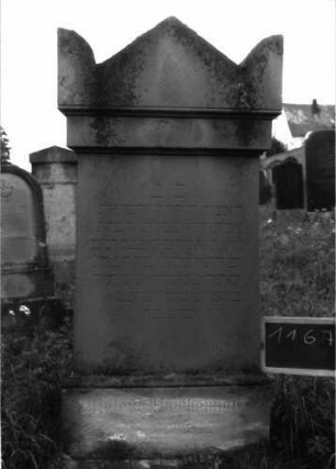Grabstein 1167 (Index: 100104298) Material: Sandstein Zustand: am Sockel stark verwittert, sonst gut erhalten Maße HxBxT: 148x66x25 cm Beschreibung: Stele auf getrepptem Sockel, getreppter Giebelaufsatz mit Eckakroterien: Grabstein 1167