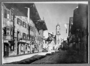 Mittenwald, Straße mit Wohn- und Geschäftshäusern an der barocken Pfarrkirche