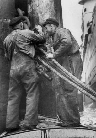 Hamburg. Hafen. Fastmoker. Hafenarbeiter vertäuen ein Schiff am Anleger. Eine schwere körperliche Arbeit