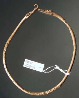 Ring mit zwei Hundeköpfen an den Enden, verbogen