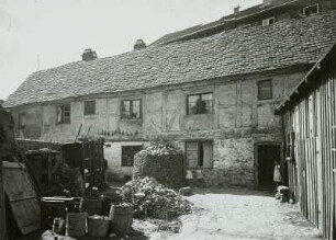 Güstrow. Fachwerkhaus der inneren Altstadt. Hof mit Abfallbehältern und Kaninchenstall