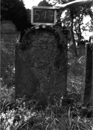 Grabstein 517 (Index: 100102593) Material: Sandstein Zustand: stark verwittert, abgeblättert, vollständiger Textverlust Maße HxBxT: 102x54x8 cm Beschreibung: Stele, eingezogener Rundbogenabschluss, Schriftfeld eingetieft: Grabstein 517