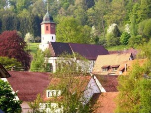 Ansicht von Nordosten mit Kirche (Chor 1489- Langhaus 1492 neu erbaut-Kirchturm im Kern Frühromanisch-Glockenstibe 18 Jh) in erhöhter Lage über Ortshäusern