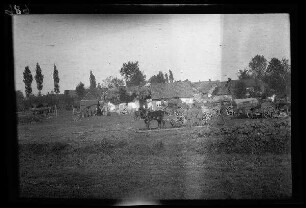 Metz-en-Couture (Dep. Pas-de-Calais, Frankreich): Pferdegespann und Fuhrwerke auf einem Platz vor der Ortschaft (Distanzaufnahme)