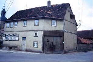 Gehöft an Straßenkreuzung mit abgeschrägter Ecke und Tordurchfahrt