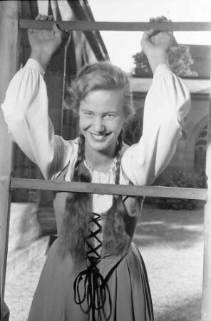 Basel, Schweiz: Komödie Basel; Immy Schell als "Gretchen" im Klosterhof des Münsters (lachend, Arme hoch am Gitter)