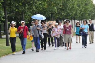 Chinesische Touristengruppe : Chinesische Touristen spazieren durch den Park von Schloss Belvedere. Aufgenommen am 3. September 2009 in Wien