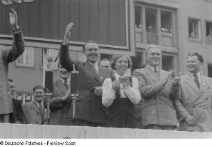 Blick auf die Tribüne mit Erich Uhlig (l.), Max Reimann (2.v.r.) und Paul Fröhlich (rechts) auf der Straße der III. Weltfestspiele (heutige Jahnallee)