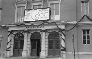 Schulgebäude : Anlässlich des Besuchs von Adolf Hitler geschmückter Eingangsbereich der Alten Nikolaischule in Salzburg.