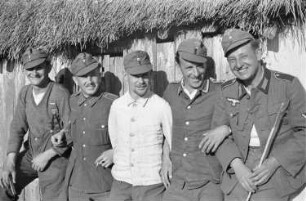 Zweiter Weltkrieg. Zur Einquartierung. Sowjetunion. Angehörige der deutschen Wehrmacht vor einer Bauernhütte