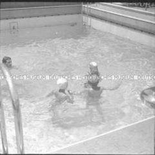 Vier Passagiere im Schwimmbad des Hochseepassagierdampfers "Columbus"