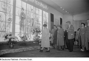 Besucher in einer Ausstellungshalle mit Blumen