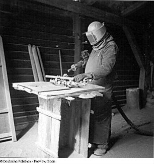 Rostock-Warnemünde. Ernst Heinkel Flugzeugwerke Warnemünde. Arbeiter bei der Arbeit mit einem Sandstrahlgebläse