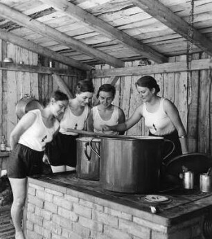 Reinwarzhofen. Zeltlager des Bundes Deutscher Mädel (BdM) auf dem Zeltlagerplatz "Göring-Espan". Mädchengruppe in Sportbekleidung am Herd in der Lagerküche