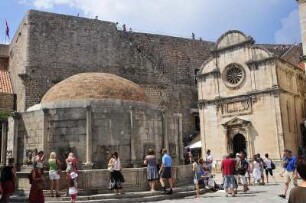 Dubrovnik - Stadtmauer und Onofriusbrunnen : Hinter dem Onofriusbrunnen und dem Eingang zum ehemaligen Franziskanerkloster erhebt sich die Stadtmauer. Aufgenommen am 2. Juli 2010 in Dubrovnik