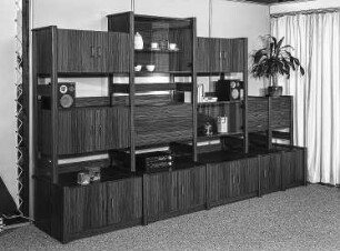 Anbauwand Ribnitz : Ribnitz-Damgarten. VEB Möbelkombinat Ribnitz-Damgarten. Hausmesse, 1986. Anbauwand Ribnitz. Holz, folienbeschichtet in Nußbaumholzoptik (1986; VEB Möbelkombinat Ribnitz-Damgarten)