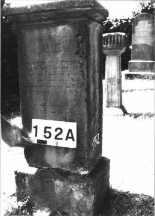 Grabstein 152 (Index: 100085445) Maße HxBxT: 107x40x29 cm Beschreibung: Stele, Sockel, Giebel, rechteckiges Schriftfeld eingetieft auf Vorderseite: Grabstein 152A