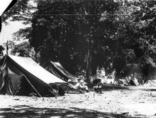 Zeltlager : Zeltlager in Mombo. Mittig drei Personen in Tropenanzügen sitzend.
