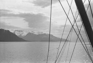 Norwegische Küste : Blick vom Schiff auf die norwegische Küste mit einem Felsmassiv am Ufer.