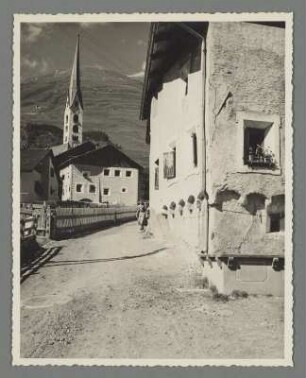 Frau in einer Tracht in einer Gasse von Zuoz