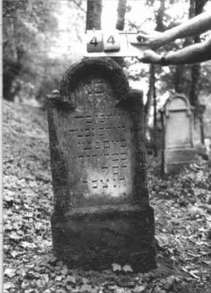 Grabstein 444 (Index: 99800238) Material: Sandstein Zustand: verwittert Maße HxBxT: 119x48x10 cm Beschreibung: Stele, eingezogener Rundbogenabschluß, Schriftfeld eingetieft, getreppter Sockel Besonderheit: Kindergrab: Grabstein 444