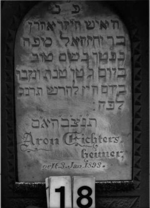 Grabstein 18 (Index: 100100624) Material: Sandstein mit weißer Marmorplatte Zustand: Sockel verwittert Maße HxBxT: 167x60x28 cm Beschreibung: ädikulaartige Stele mit Pilastern, Sockel, Giebel und Akrotere, eingetiefte Schrifttafel mit Rundbogen Symbolik: Blüten, Blätter, Zweige, um die Schrifttafel laufendes Fries, Girlande im Sockel: Grabstein 18 (Detailaufnahme)
