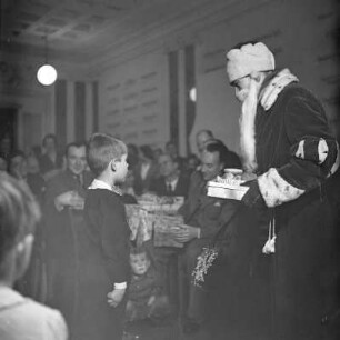 Kleiner Junge steht vor dem Weihnachtsmann, Kinderfest zur Weihnachtszeit