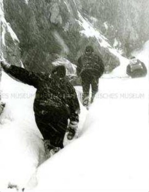 Rückenansicht dreier Männer im Schnee in den Bergen