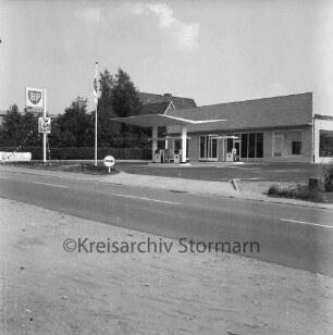 BP-Tankstelle: Hamburger Straße: Neubau: rechts Gebäude: davor Zapfsäulen: links BP-Schild: dahinter Bäume und Wohnhäuser