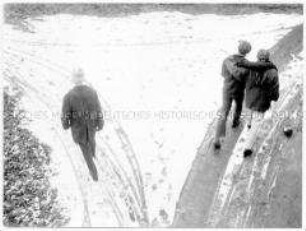 Spaziergänger im Schnee aus der Vogelperspektive fotografiert