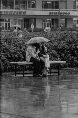 Junges Paar im Regen in der Grünanlage am Fuße des Berliner Fernsehturms, Mai 1975. SW-Foto © Kurt Schwarz.