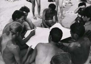Italien. Braungebrannte Männer am Strand der italienischen Riviera. Man unterhält sich und spielt