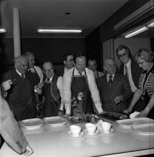 Kochwettbewerb Kreistag und Lübecker Nachrichten: Versuchsküche der Schleswag: Präsentation und Aufschneiden des Fleisches: Begutachtung durch Hermann Bössow, Kreisrat Wilfried Busch, Kreisrat Herbert Breede, Kreispräsident Hubert Priemel, Landrat Hans-Henning Becker-Birck, Verwaltungsmitarbeiter Willy Eberhardt