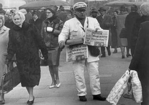 Während der Rushhour bietet der Zeitungsverkäufer den Passanten die "Bild" Zeitung an.