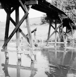 Klein Barnitz: Trave: Holzbrücke für Fußgänger mit Schäden an den Jochen: hinten Wiesen
