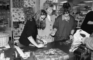 Kaufhaus Mohr: Verkaufsoffener Samstag: Haushaltswarenabteilung: Verkäuferin Gerlinde Prasch gibt Ratschläge an Aushilfen Sebnem Patlak und Sandra Gustävel beim Verpacken von Geschenken: 20. Dezember 1998