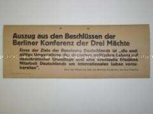 Maueranschlag mit einem Zitat aus der Mitteilung zur Dreimächtekonferenz in Berlin